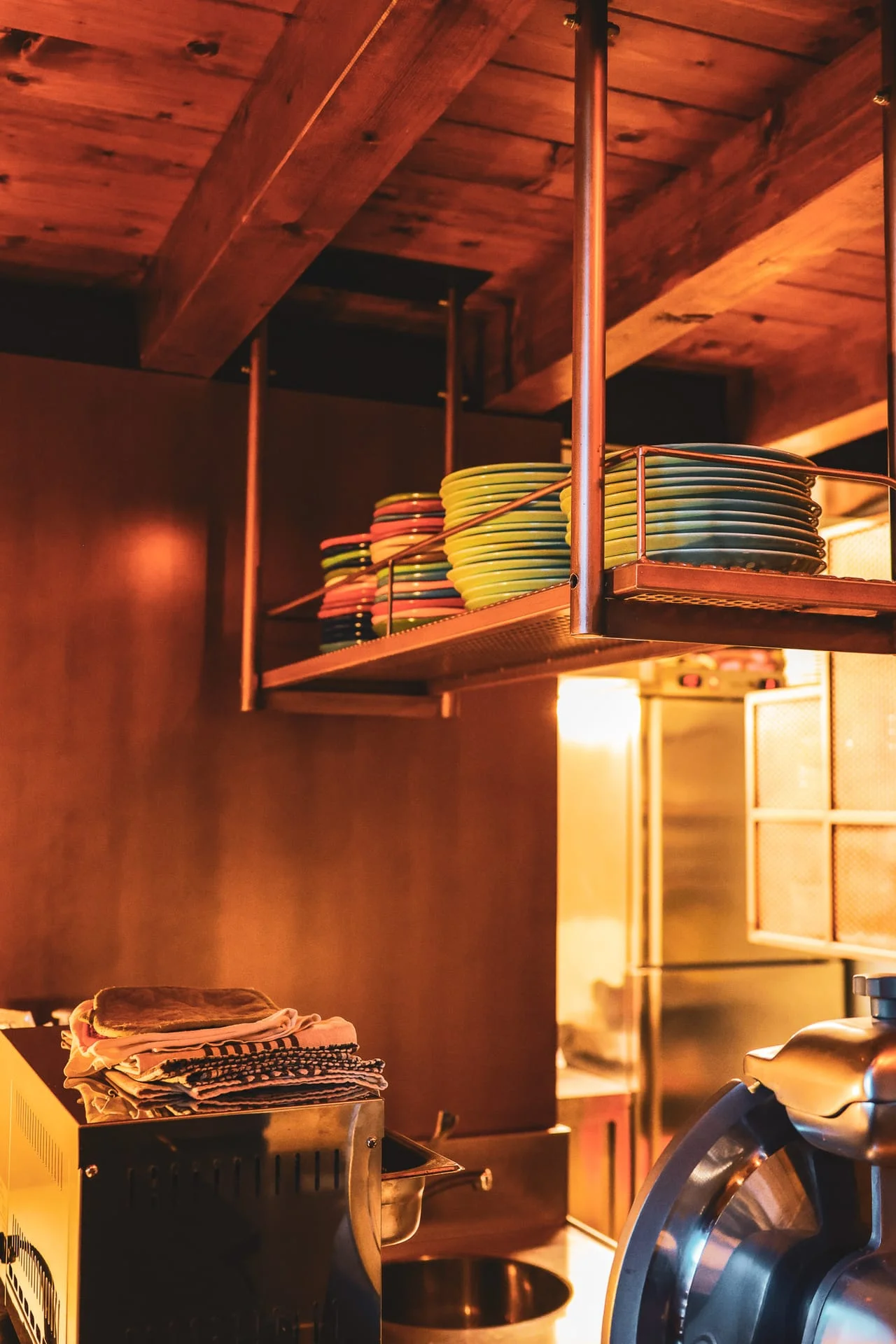 La cucina di T'S WAY con i piatti colorati impilati sulla mensola